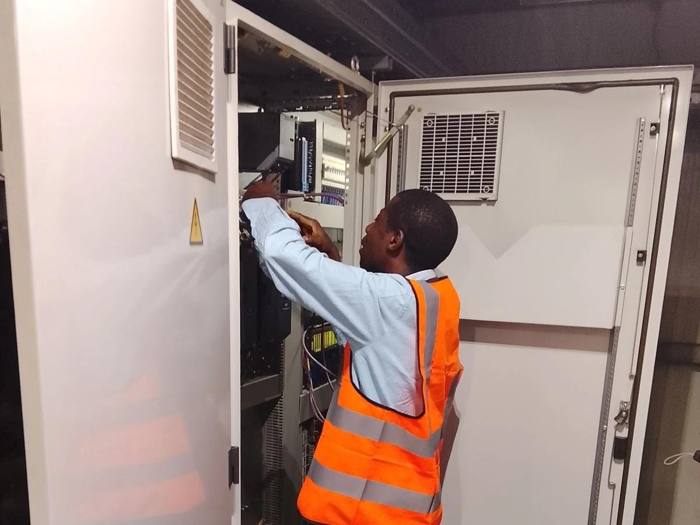 Technician servicing a variable frequency drive control cabinet