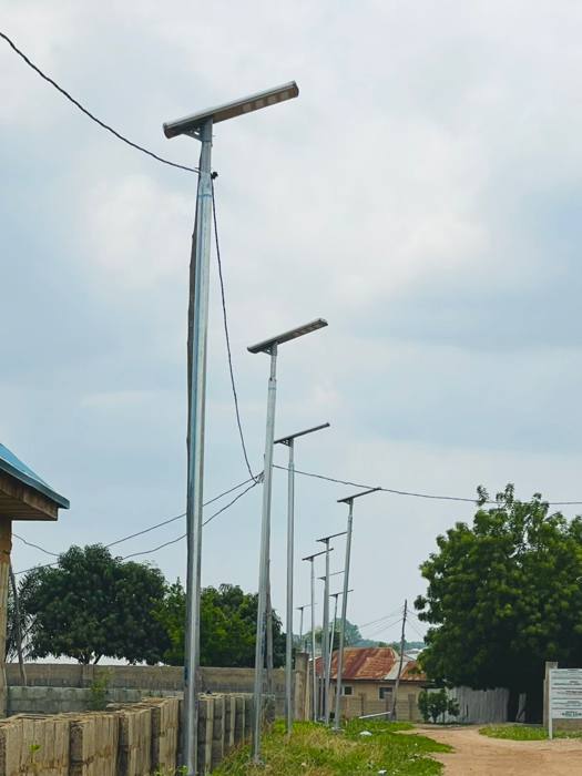 Solar street lighting poles installed along a roadway during the day